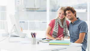 Portrait of a smiling casual business couple sitting in a bright office
